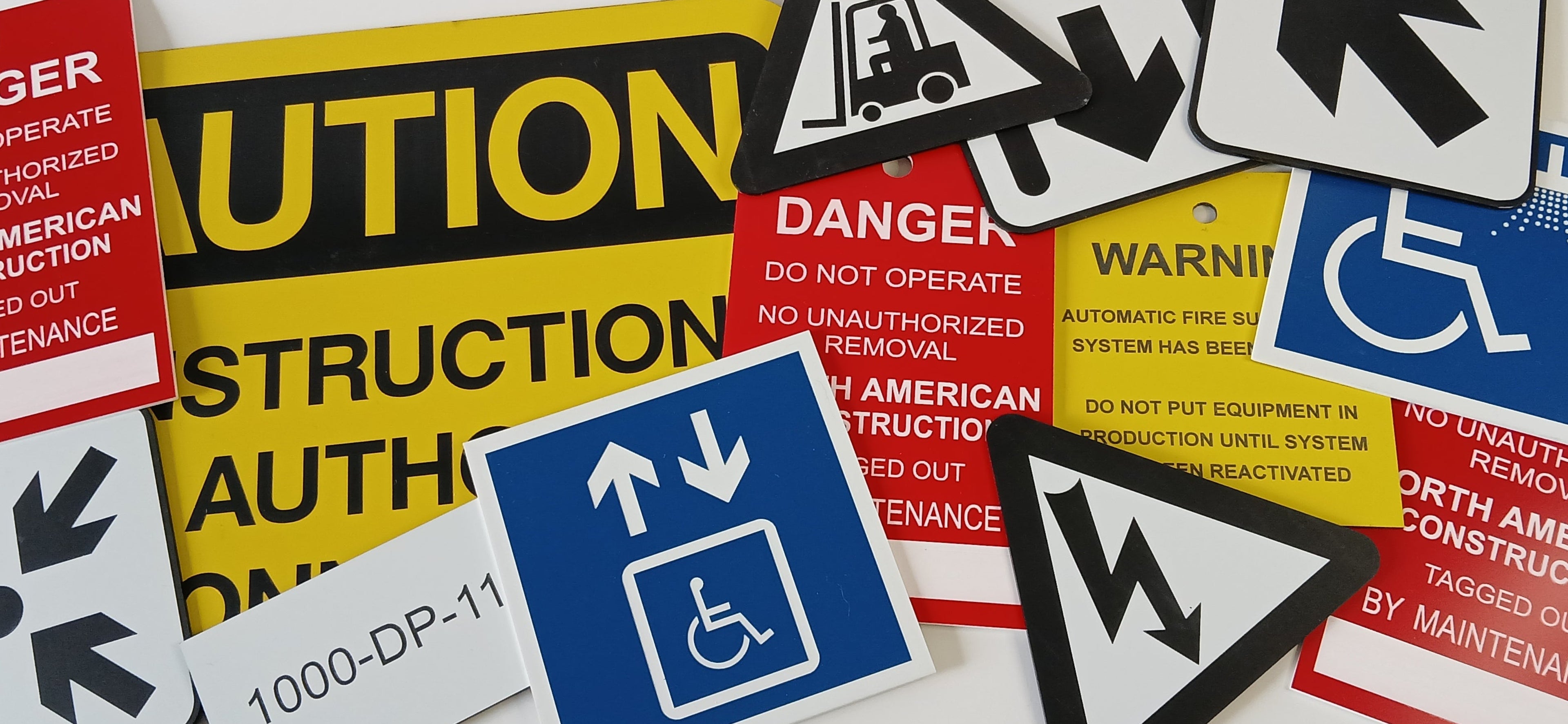 Collection of custom engraved 2-ply plastic (lamacoid), acrylic warning and instruction signs on a white background