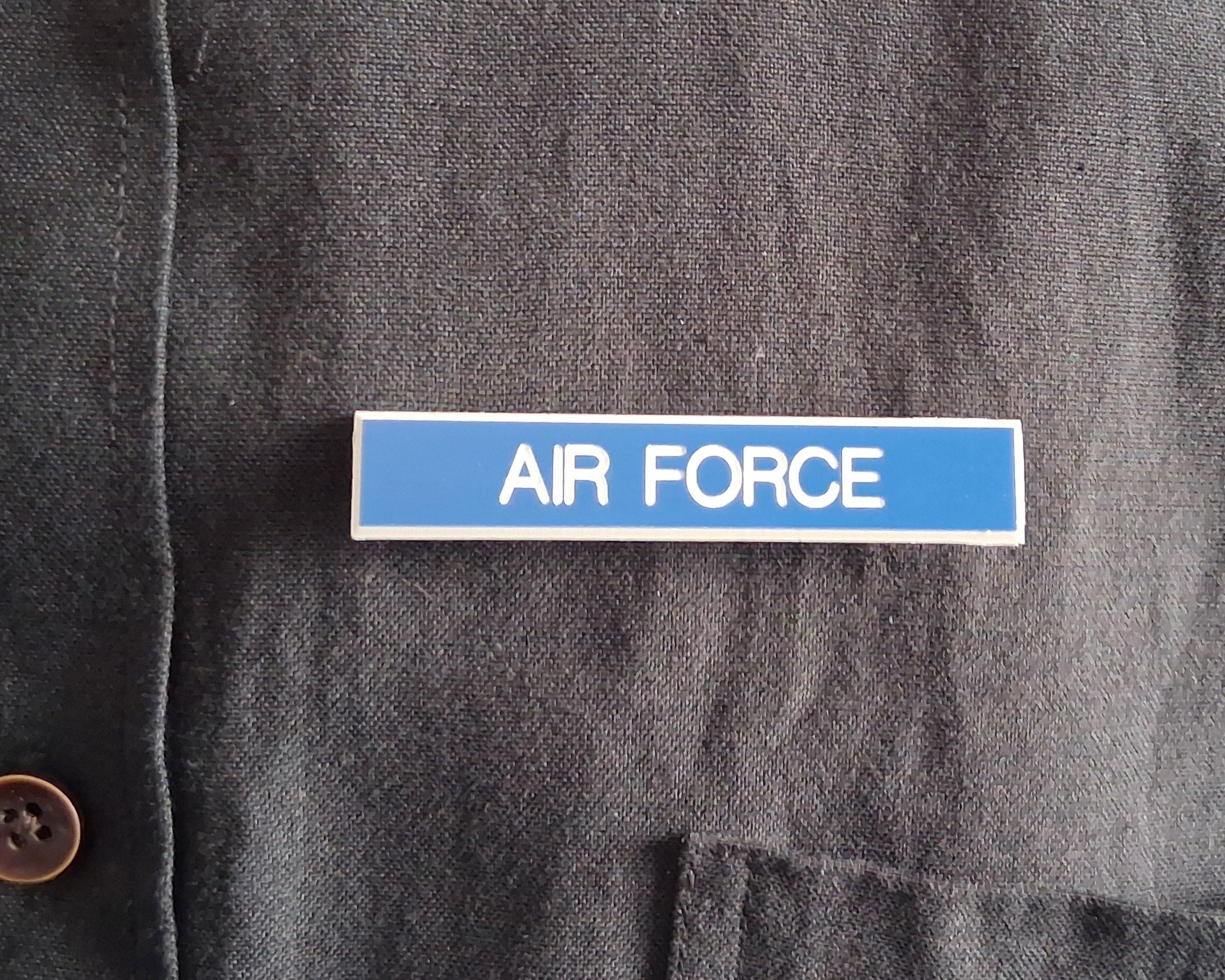 Dark gray shirt with custom engraved and compliant name tag with a 'AIR FORCE' label on a blue background