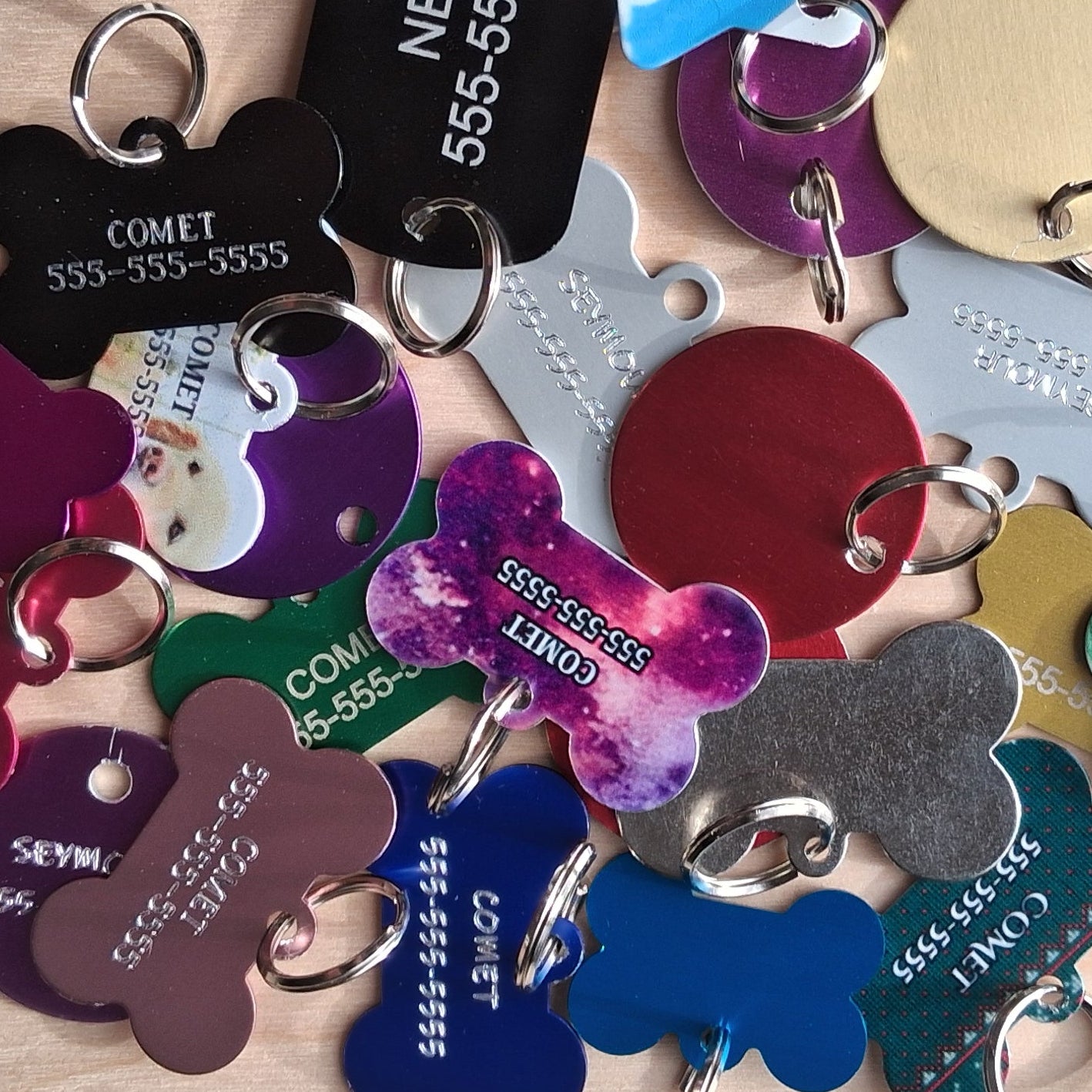 Collection of colorful custom engraved pet tags with engraved names and phone numbers