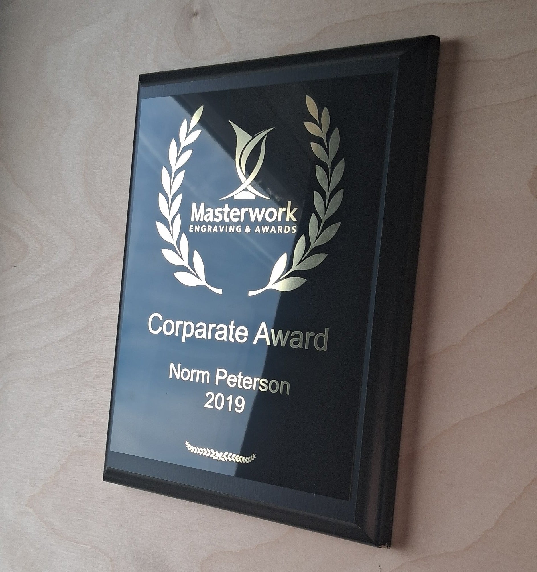 Custom engraved award plaque on a wooden wall